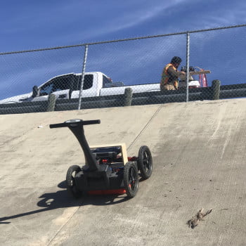 View of surveying rip rap concrete wall with a 4 wheel cart and a 350 HS antenna.